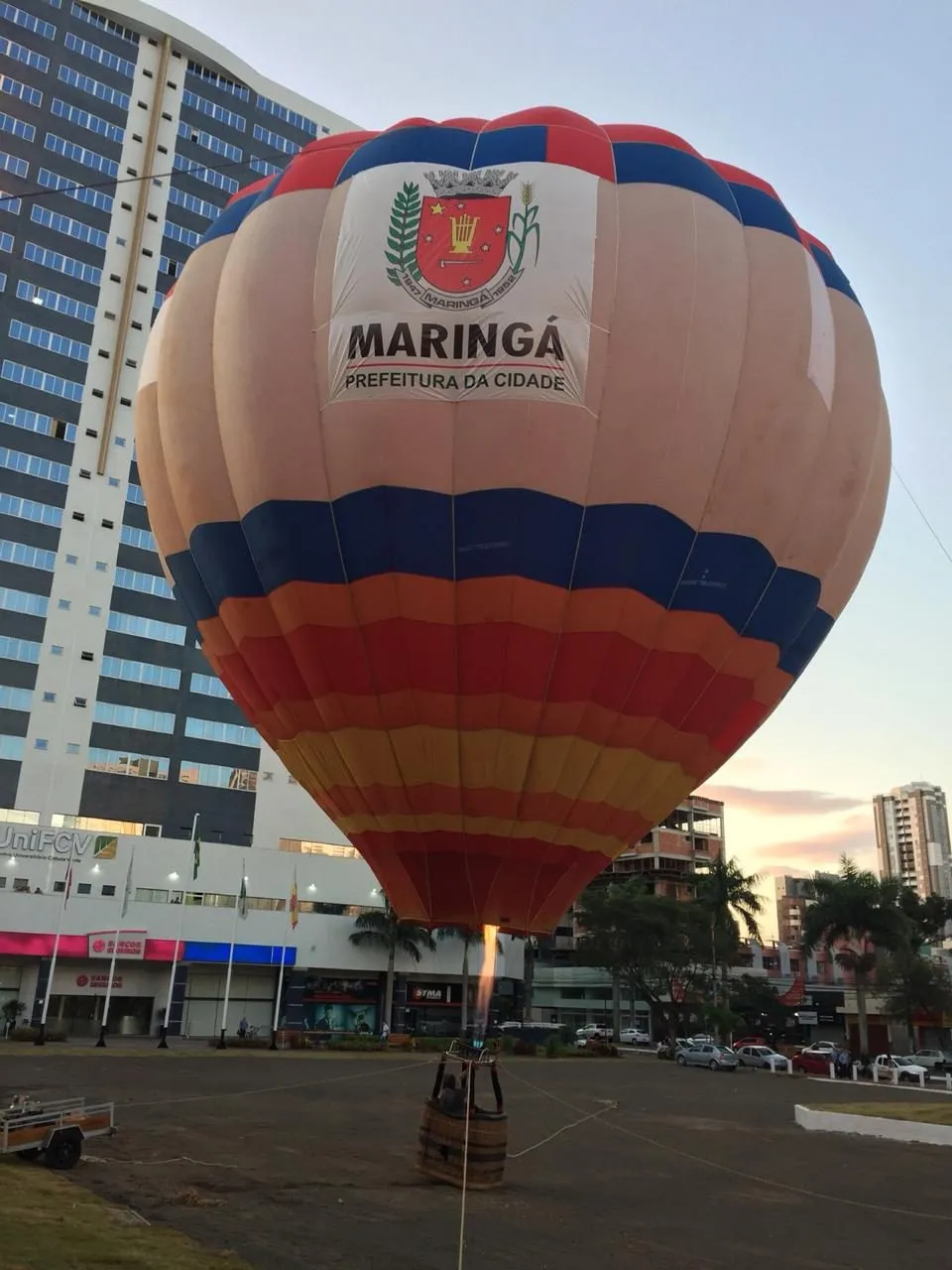 Balão com a marca de Maringá ao lado de um prédio